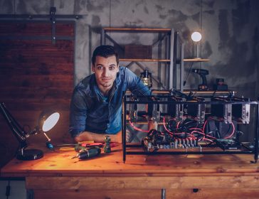 Man next to mining rig for cryptocurrency