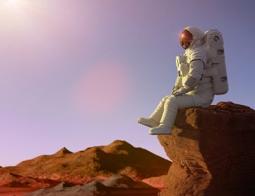 Astronauta che guarda l'orizzonte vestito con una tuta spaziale