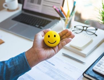 Emoticon ball on male hand on work table.happy life concepts.inspiration and motivation idea